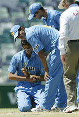 India's Ashish Nehra (left) rubs his arm after a fall as his teammates look on during the triangular series One-Day International against Zimbabwe