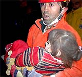 A Turkish rescue worker carries three-year-old Husniye Turkoglu after she was pulled out of the rubble of a 10-storey building which collapsed in Konya, central Turkey