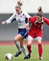 US player Lindsay Tarpley vies for the ball with Canadian player Christine Sinclair 