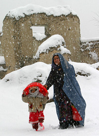 A woman and her child make their way through heavy snow fall in Kabul 