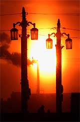 Sun sets behind Lieutenant Shmidt Bridge on the Neva river in St. Petersburg