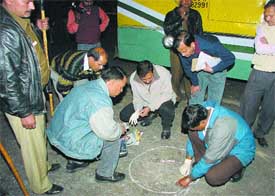 Forensic experts and policemen inspect the blast site near the IIT flyover