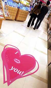 A couple walks through a shop on Thursday with a loveheart on the floor to promote Valentine's Day which falls on Saturday.