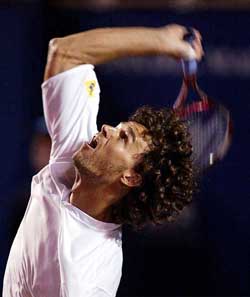 Brazilian tennis player Gustavo Kuerten serves against Franco Squillari