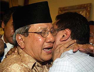 Indonesian Parliament Speaker Akbar Tandjung cries as he is greeted by a supporter