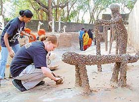 Isabel Brunt of the Nek Chand Foundation and Garima Vashisht of the Friends of Nek Chand do mud plastering at Rock Garden