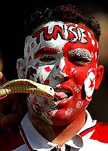 A Tunisian fan kisses a wooden snake