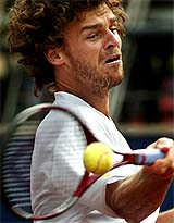 Gustavo Kuerten of Brazil plays a forehand to David Sanchez 