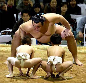 Japanese sumo wrestler Takanonami faces off against Japanese children at the Seoul Sumo tournament in Seoul 