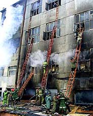 Firemen try to enter a burning five-storey shopping mall in Jilin City in northeast China�s Jilin Province