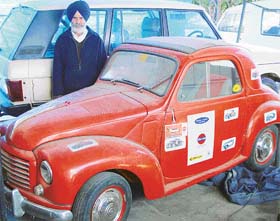 Amarjit Singh Sodhi, poses with his red beauty, a 1951 model of Fiat convertible