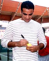 Ace bowler Zaheer Khan signs on a tennis ball during the inauguration of Hyderabad Open WTA tennis tournament in Hyderabad 