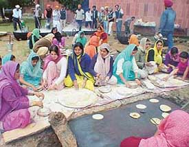 Girl students of various departments of Panjab University roll out chappatis at the community kitchen organised at the campus as a part of the Guru Gobind Singh Parkash Utsav 