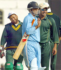 Pakistan's veteran cricket team captain Ijaz Ahmed congratulates Dinesh Mongia as Pakistan wicketkeeper Ashraf Ali looks on during a one-day game