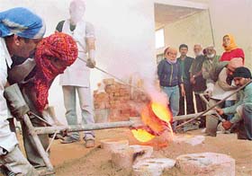 Students and faculty members of the Sculpture Department of the Government College of Art, Chandigarh, cast metal