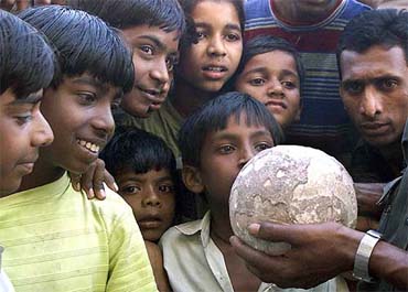A group of children look at a dinosaur egg displayed in Balasinore, 85 Km south of Ahmedabad, on Monday