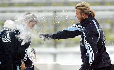 Real Madrid's British midfielder David Beckham throws a snowball at his teammate Santiago Solari from Argentina during a practice session in Munich 