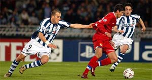 Olympique Lyon's Edmilson fights for the ball with Real Sociedad's Serbian Darko Kovacevic and Nihat Kahveci during their Champions League first-leg knockout match 