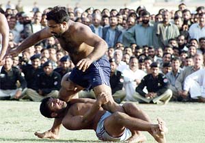 A Pakistani wrestler holds an Indian wrestler during a Kabaddi match in Rawalpindi on Thursday