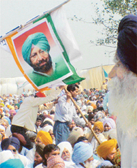 Congress supporters hold a poster of Capt Amarinder Singh at a celebration in Latala village