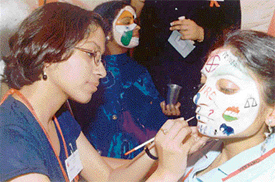 A participant paints symbols of various political parties in a face-painting competition at the Punjab College of Technical Education in Ludhiana