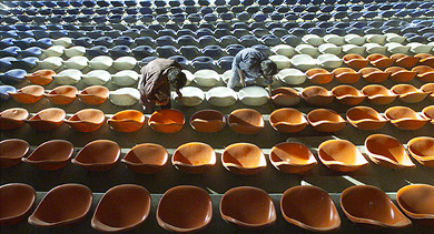 Workers fix seats at Karachi's National stadium for India's forthcoming Pakistan tour on Friday