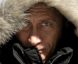 Russian President Vladimir Putin adjusts the hood of his jacket at Ovsyanka village in Krasnoyarsk region during his pre-election trip to Siberia 