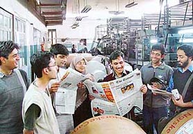 Students from the Lahore University of Management Sciences go through a copy of The Tribune newspaper during their visit to the office 