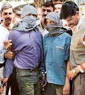 The brother of Sher Singh Rana, the prime accused in the Phoolan Devi murder case, Vikram Rana (centre), and an unidentified person, suspected accomplice who helped Sher Singh Rana escape from Tihar Jail, at the Delhi police special cell in New Delhi after they were arrested 