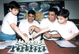 National Under-11 chess champion Parimarjan Negi and one of the youngest chess players Sahaj Grover display their moves as chairman of Parsvnath Pradeep Jain and Delhi Chess Association secretary Bharat Chauhan watch while announcing the second International Open Chess Tournament at the Russain Centre in New Delhi on Wednesday.