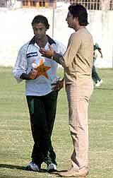 Former Pakistan's ace pacer Wasim Akram who was specially called to Pakistan's cricket camp to share his skill with other players, talks to Shoaib Akhtar during a net practice at Gadaffi Stadium