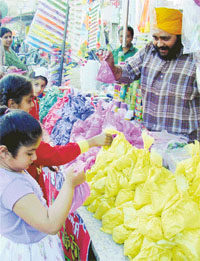 Children buy colours for Holi in Ludhiana on Friday