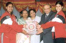 Delhi University Director of Sports Dr Sudarshan Pathak and registrar of the university Kanwar Manjit Singh presenting the Inter-College Yoga Championship title to the players of Kalindi College