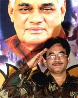 Bollywood actor Deepak Divekar poses as Pervez Musharraf in front of a portrait of Atal Bihari Vajpayee in Bangalore on Saturday