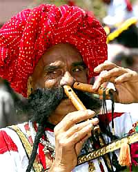 An artist plays two flutes with his nostrils simultaneously during the Elephant Festival in Jaipur 