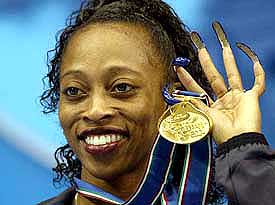 Gail Devers of the US shows her medal after winning the women's 60-m sprint event at the World Indoor Athletics Championships in Budapest