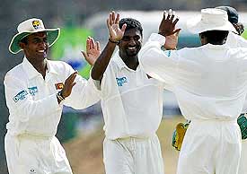 Sri Lankan off-spinner Muttiah Muralitharan celebrates with teammates Hashan Tillakaratne and Marvan Atapattu after dismissing Australia's Stuart MacGill 