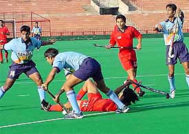 A player lies sprawled on the ground during the junior India-Malaysia hockey match in the Chandigarh