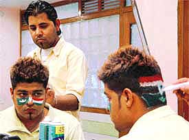 A cricket fan gets his head and face painted in Indian and Pakistani colours in Ambala 