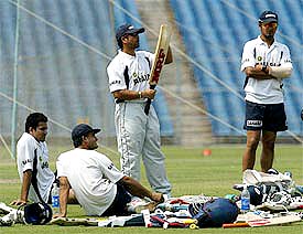 India's star batsman Sachin Tendulkar checks a bat as Murali Kartik, captain Sourav Ganguly and Zaheer Khan look on