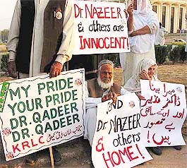 Parents of detained Pakistani nuclear scientist Nazeer sit in protest before the Parliament in Islamabad on Monday