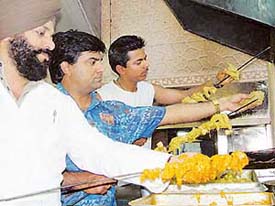 Chefs spike the special green tandoori chicken at Chawla�s chicken. Tribune photo: Malkiat Singh