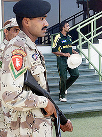 Pakistan's fast bowler Shoaib Akhtar enters the field amid tight security during a practice match between Pakistan A and Pakistan B cricket teams at National Stadium, Karachi, on Wednesday.