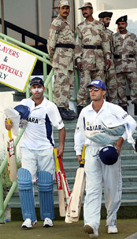India's captain Saurav Ganguly and team-mate Yuvraj Singh walk on to the ground for a training session under the watchful eyes of Pakistani security personnel in Karachi on Friday ahead of their One-Day International match against Pakistan
