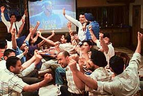 Youths enjoy the cricket match between India and Pakistan on screen with a pint of beer in Chandigarh