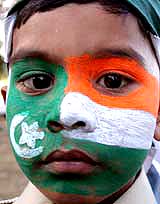 A young cricket fan with both Pakistani and Indian flag painted on his face waits outside the National Stadium