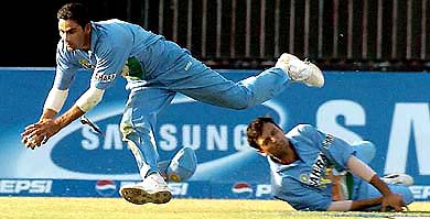 Indian fielder Mohammed Kaif collides with team-mate Hemang Badani (R) as he successfully takes a catch to dismiss Pakistani cricketer Shoaib Malik