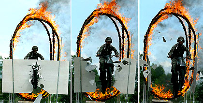 A Thai soldier rides a motorcycle through a fire ring at a military camp in Pattani 