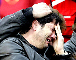 A man being consoled at a funeral mass for victims of  Madrid bombings, held at the Alcala de Henares sports pavilion near Madrid on Saturday.