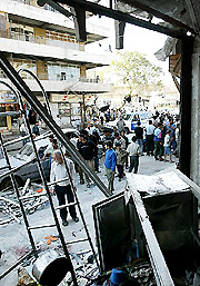Iraqis view a destroyed clothing and accessories shop after a bomb exploded in the upmarket Baghdad neighbourhood of Karrada on Saturday.